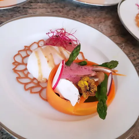 Entrée gastronomique : asperges, mousse légère et fleurs comestibles